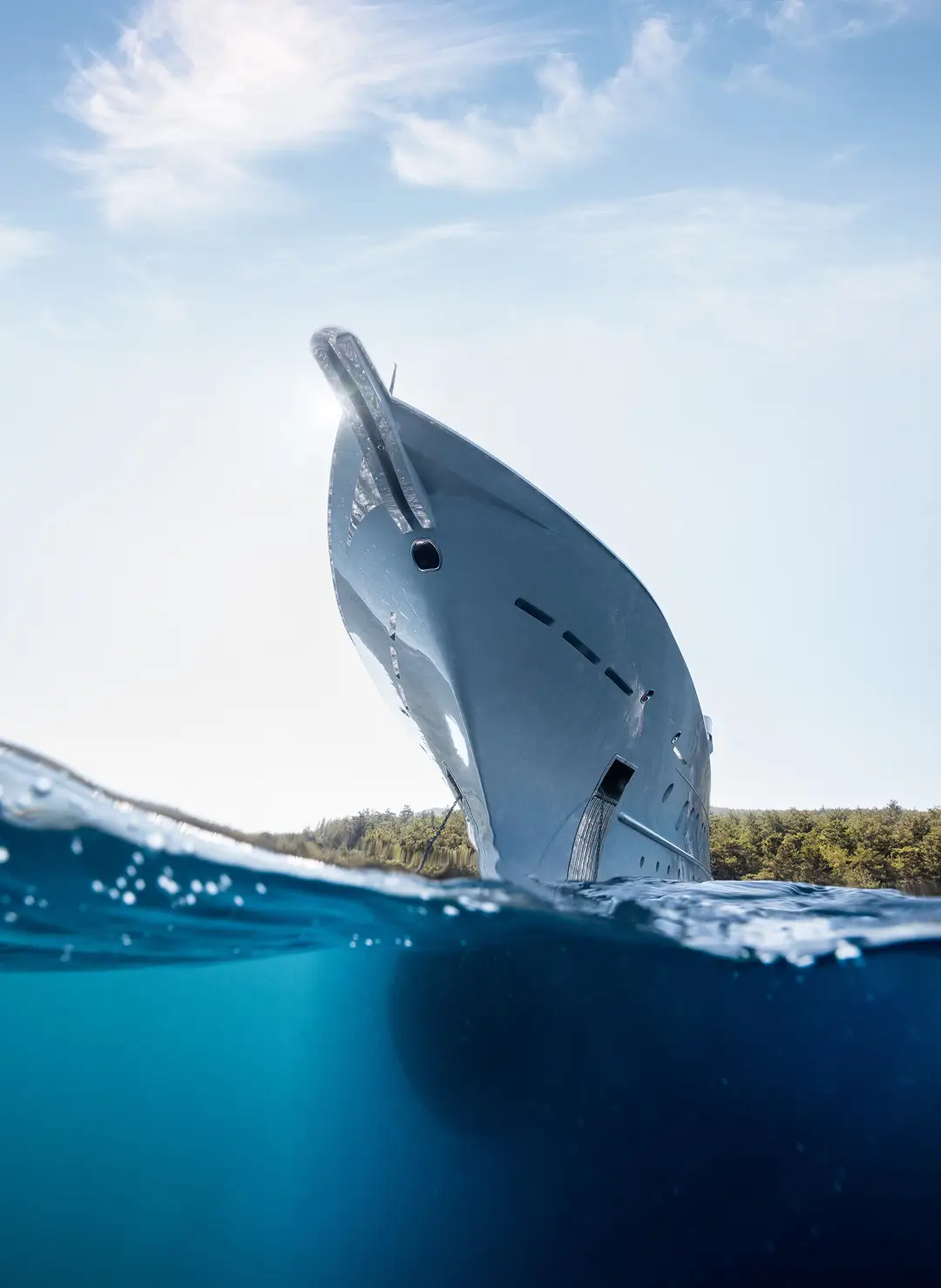 Bow of a modern superyacht photographed from the waterline, showcasing sleek hull design and luxury maritime engineering.