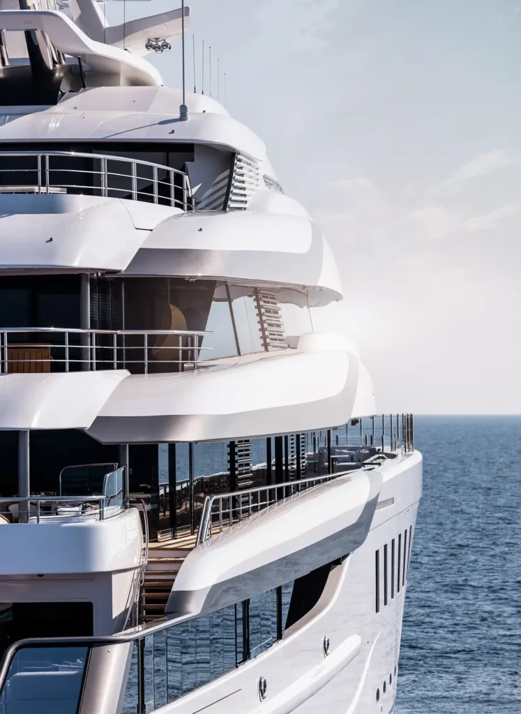 Close-up view of a luxury superyacht’s multi-level exterior decks with curved white structures overlooking the open sea